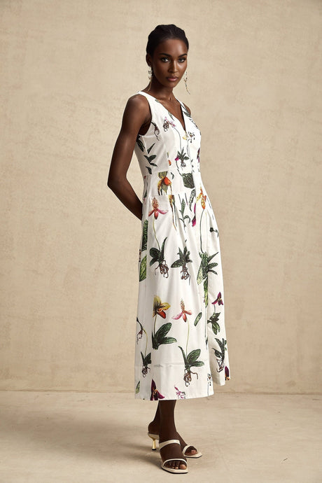 Woman wearing a floral print midi dress with vneck and poplin fabric in vibrant colors against a plain background