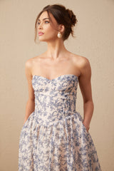Woman wearing a floral print offshoulder midi dress with a fitted bodice and flared skirt