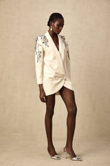 Woman wearing a formal black blazer dress with sparkling sequin embellishments
