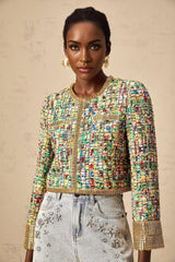 Woman wearing a gold sequined tweed jacket with a checked pattern and gold tone accents