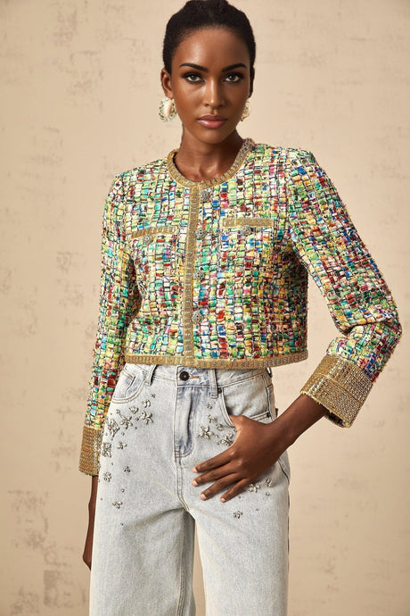 Woman wearing a gold sequined tweed jacket with a checkered pattern and gold tone buttons