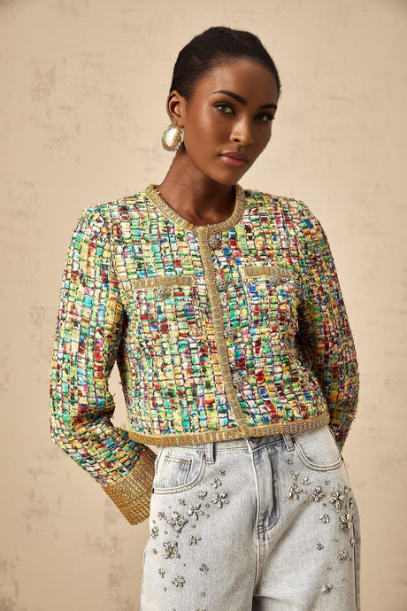 Woman wearing a goldtone tweed jacket with sequin embellishments and a checked pattern