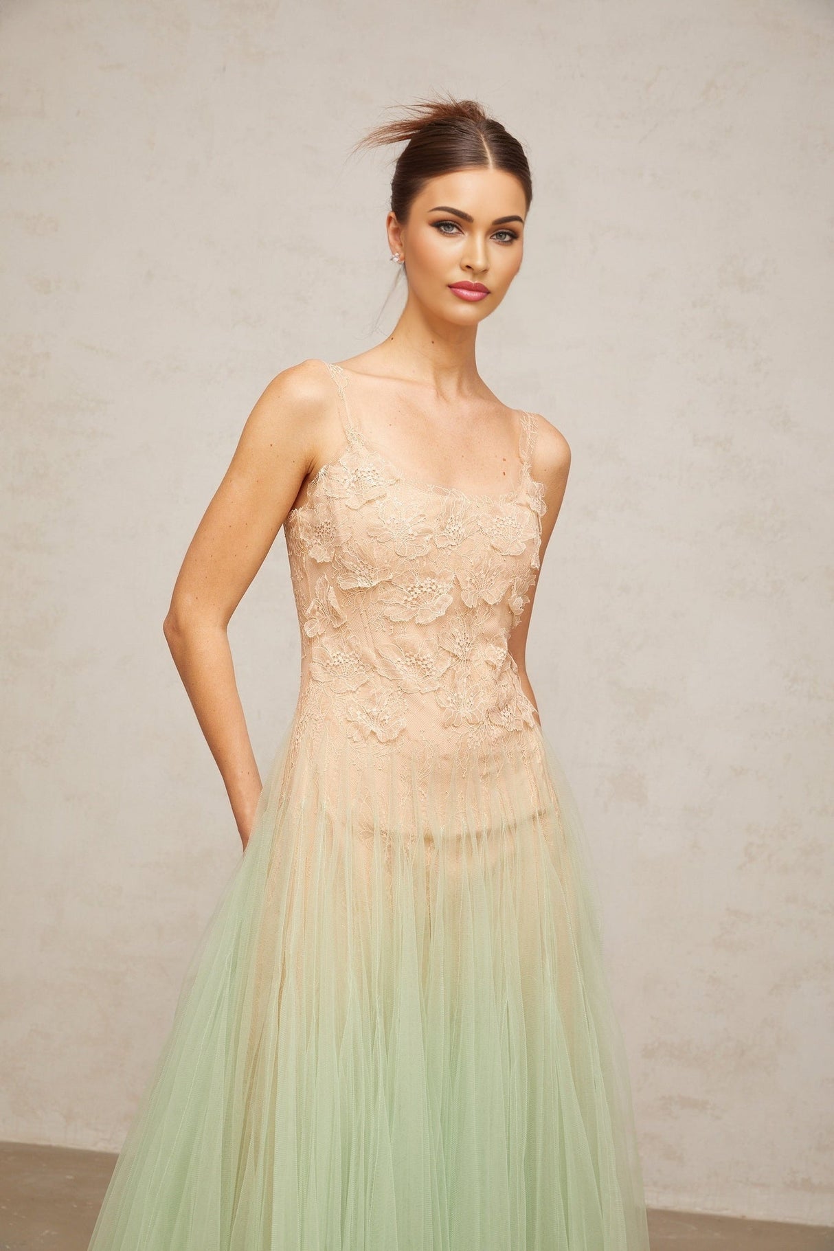 Woman wearing a green midi dress with lace panels and tulle skirt