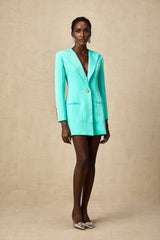Woman wearing a green mini blazer dress with cinched waist
