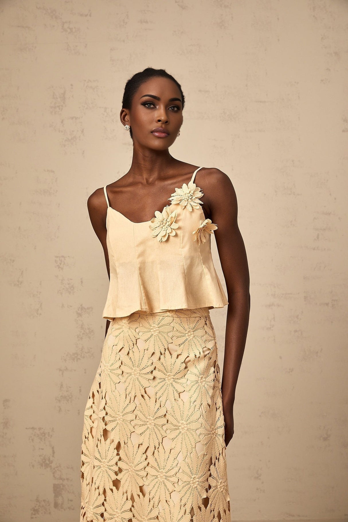 Woman wearing a khaki colored matching set consisting of a cutout flared top and skirt by Celine