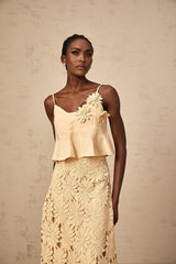 Woman wearing a khaki colored matching set consisting of a cutout flared top and skirt by Celine