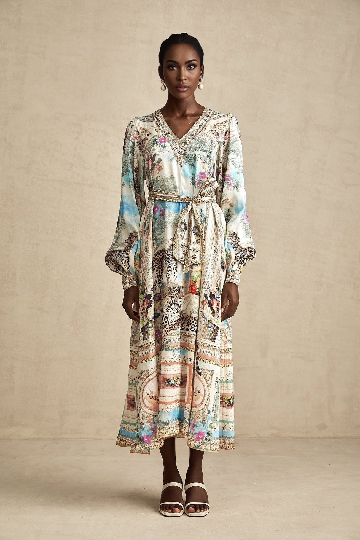 Woman wearing a knee length belted dress with V neckline in solid color fabric