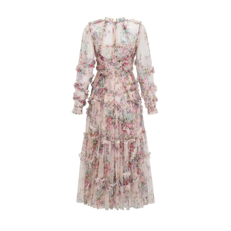 Woman wearing a lightcolored floral midi dress with ruffled details and tulle fabric standing in a neutral background