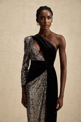 Woman wearing a long asymmetric dress with sequin embellishments shimmering under light