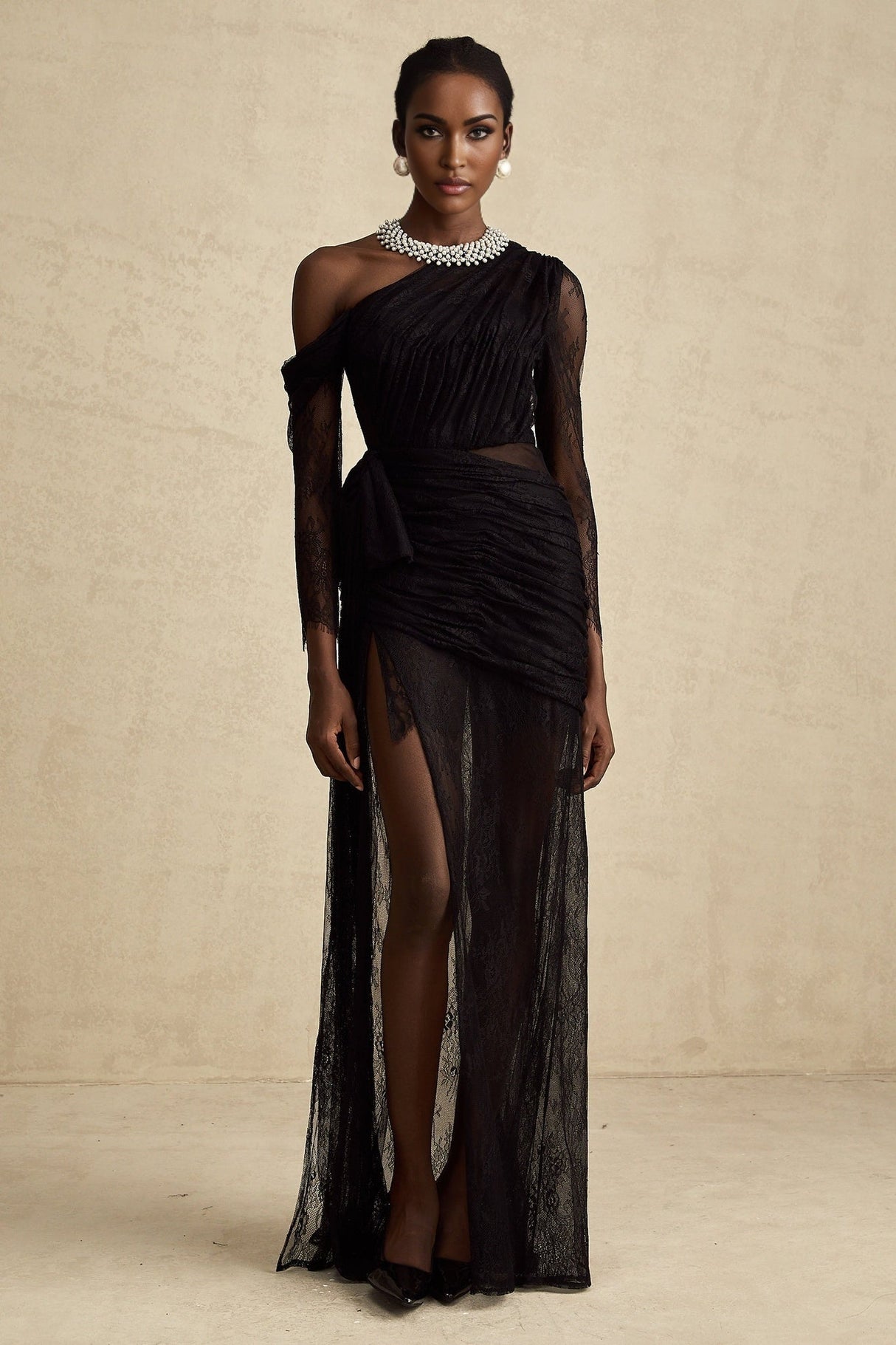 Woman wearing a long black dress with one shoulder strap and a cutout detail on the side