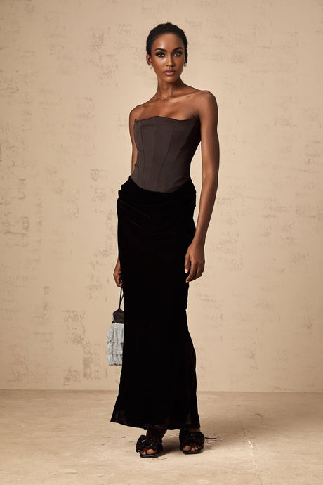 Woman wearing a long black velvet off shoulder maxi dress
