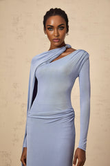 Woman wearing a long blue fitted maxi dress with a diagonal shawl neckline detail