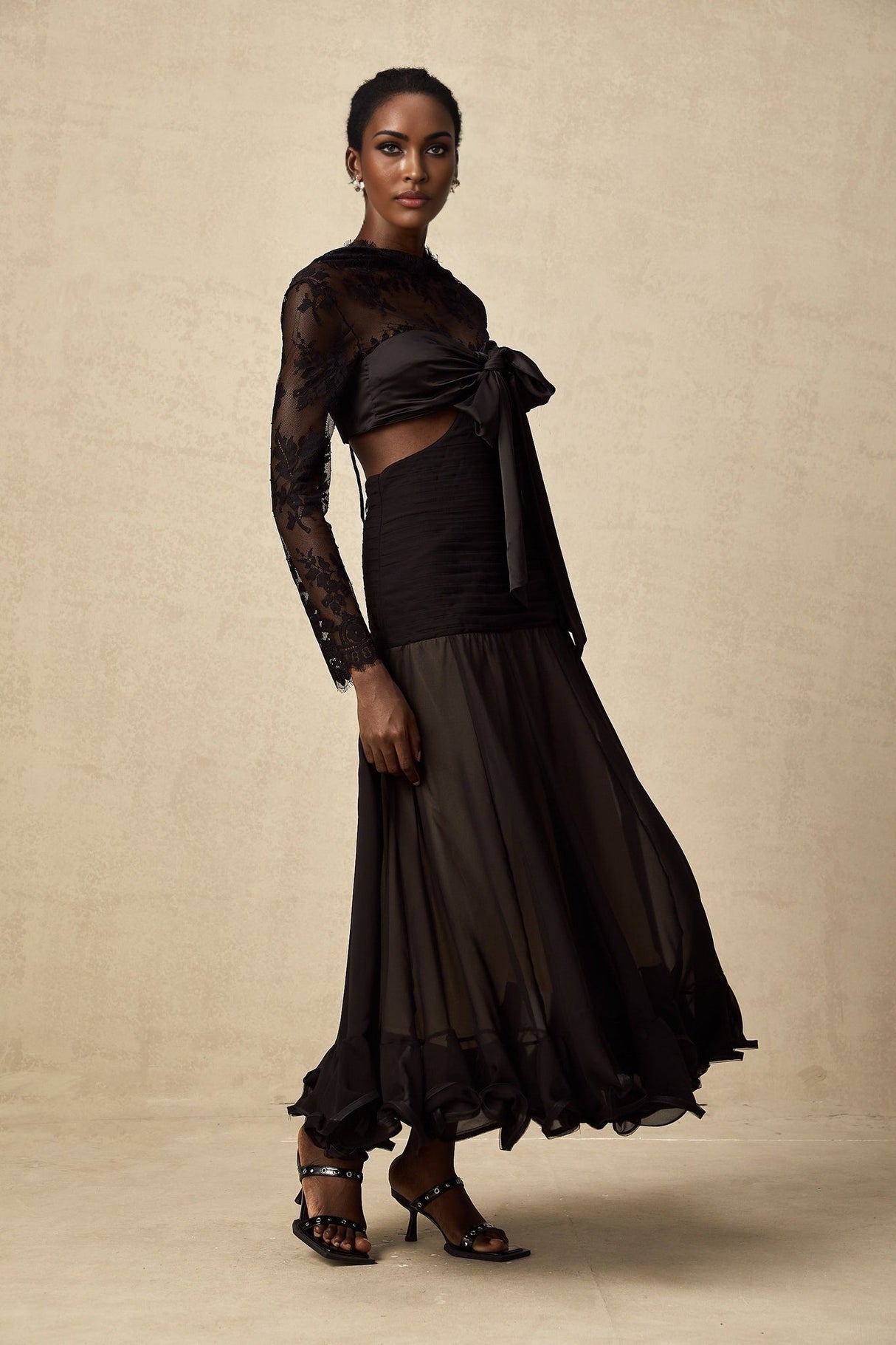 Woman wearing a long floral lace maxi dress with sheer panels elegant design in light color