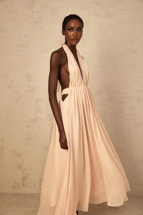 Woman wearing a long flowy halterneck maxi dress with shirred bodice and tulle skirt