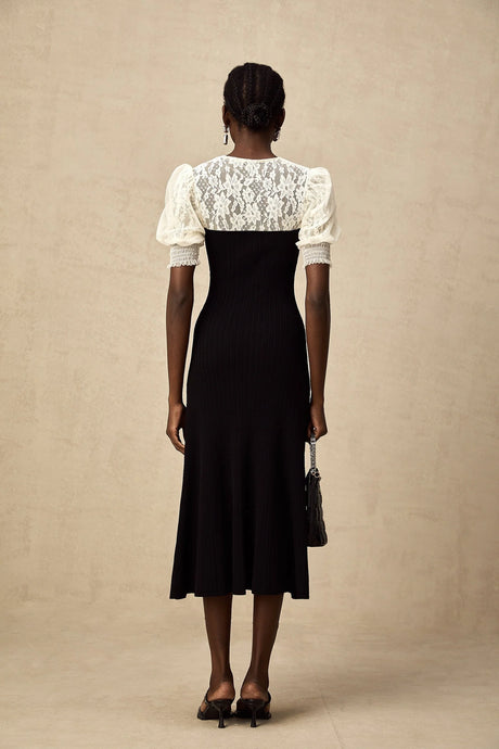 Woman wearing a long knit midi dress with lace trim details