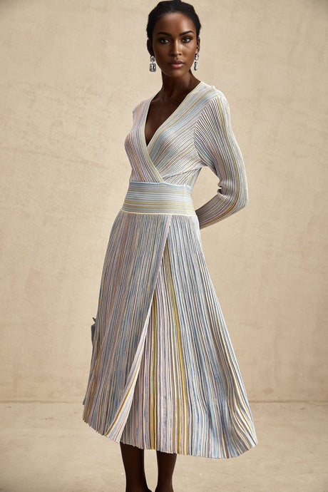 Woman wearing a long knitted dress with vertical stripes standing in a casual pose