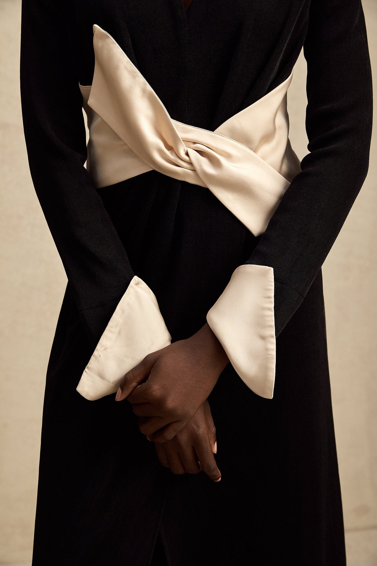 Woman wearing a long maxi dress with contrasting colors and a bowknot detail at the vneck