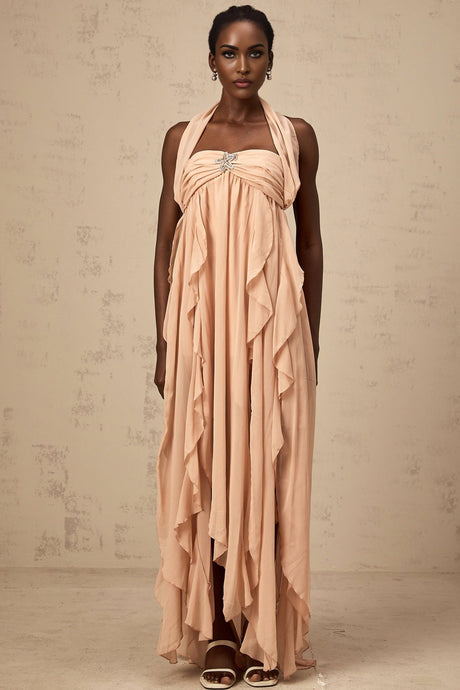 Woman wearing a long pink chiffon maxi dress with ruffles and halter neck style