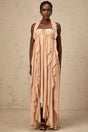 Woman wearing a long pink chiffon maxi dress with ruffles and halter neck style