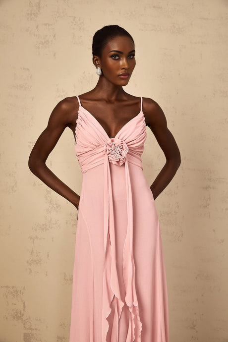 Woman wearing a long pink maxi dress with 3D floral petal details on tulle fabric flowing silhouette elegant formal gown