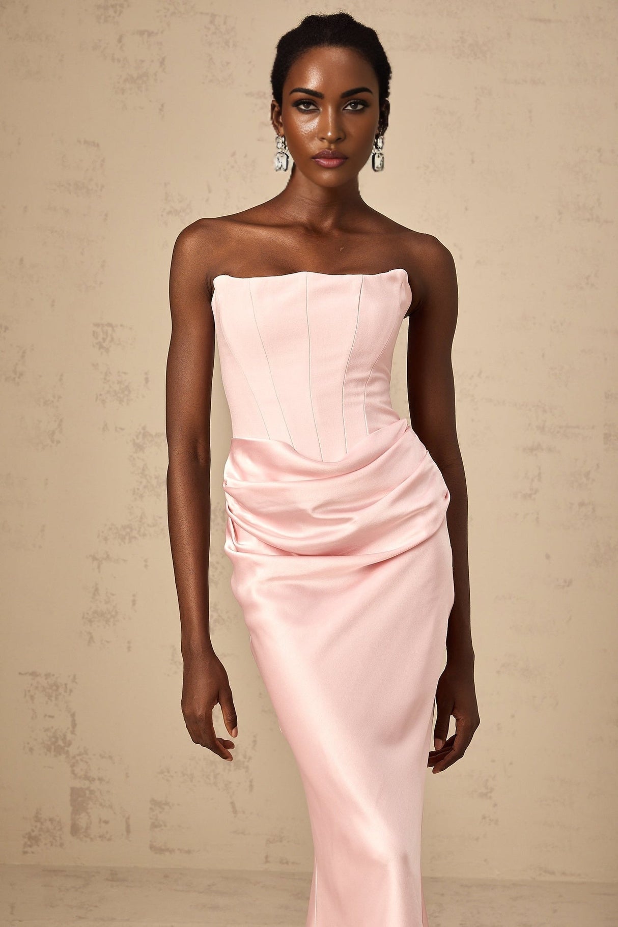 Woman wearing a long pink offshoulder maxi dress with flowing fabric standing in a relaxed pose
