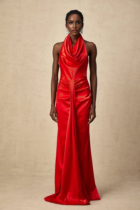 Woman wearing a long red satin maxi dress with halter neckline and draped design