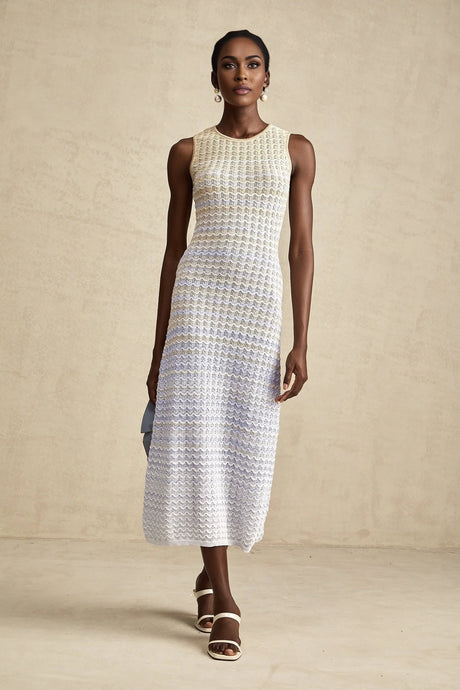 Woman wearing a long ribbed knit dress with contrasting color details and a midi length silhouette