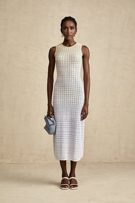 Woman wearing a long ribbed knit dress with contrasting color details and a midi length