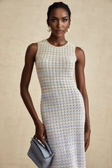 Woman wearing a long ribbed knit dress with contrasting color details and a midi length