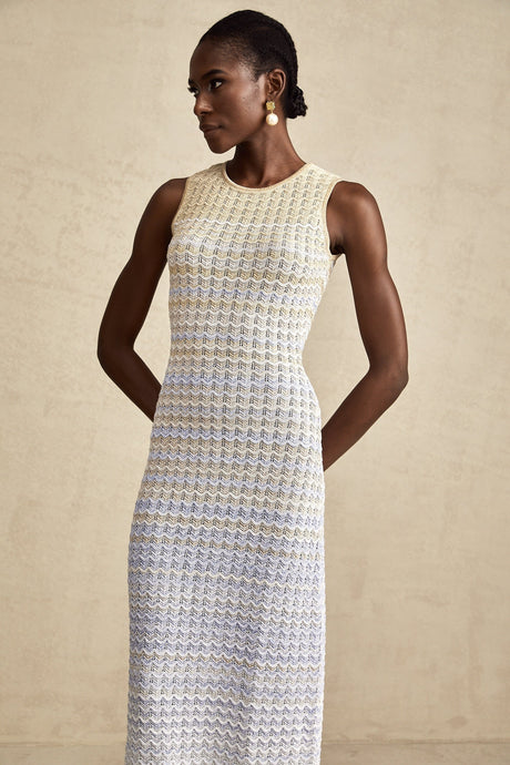 Woman wearing a long ribbed knit dress with contrasting color details and midi length