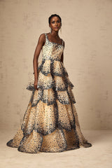 Woman wearing a long tiered maxi dress with sequined petal details and a flowing silhouette