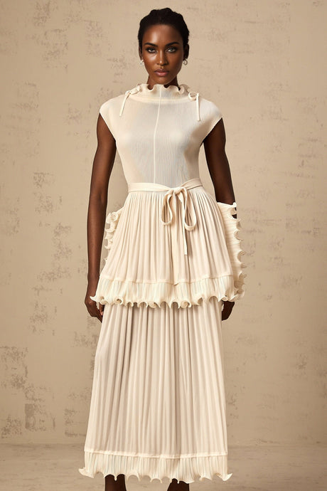 Woman wearing a long white sleeveless maxi dress with ruffles and pleats