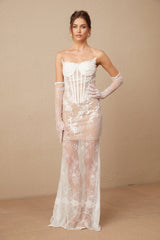 Woman wearing a long white tulle maxi dress with floral embroidery and corset bodice