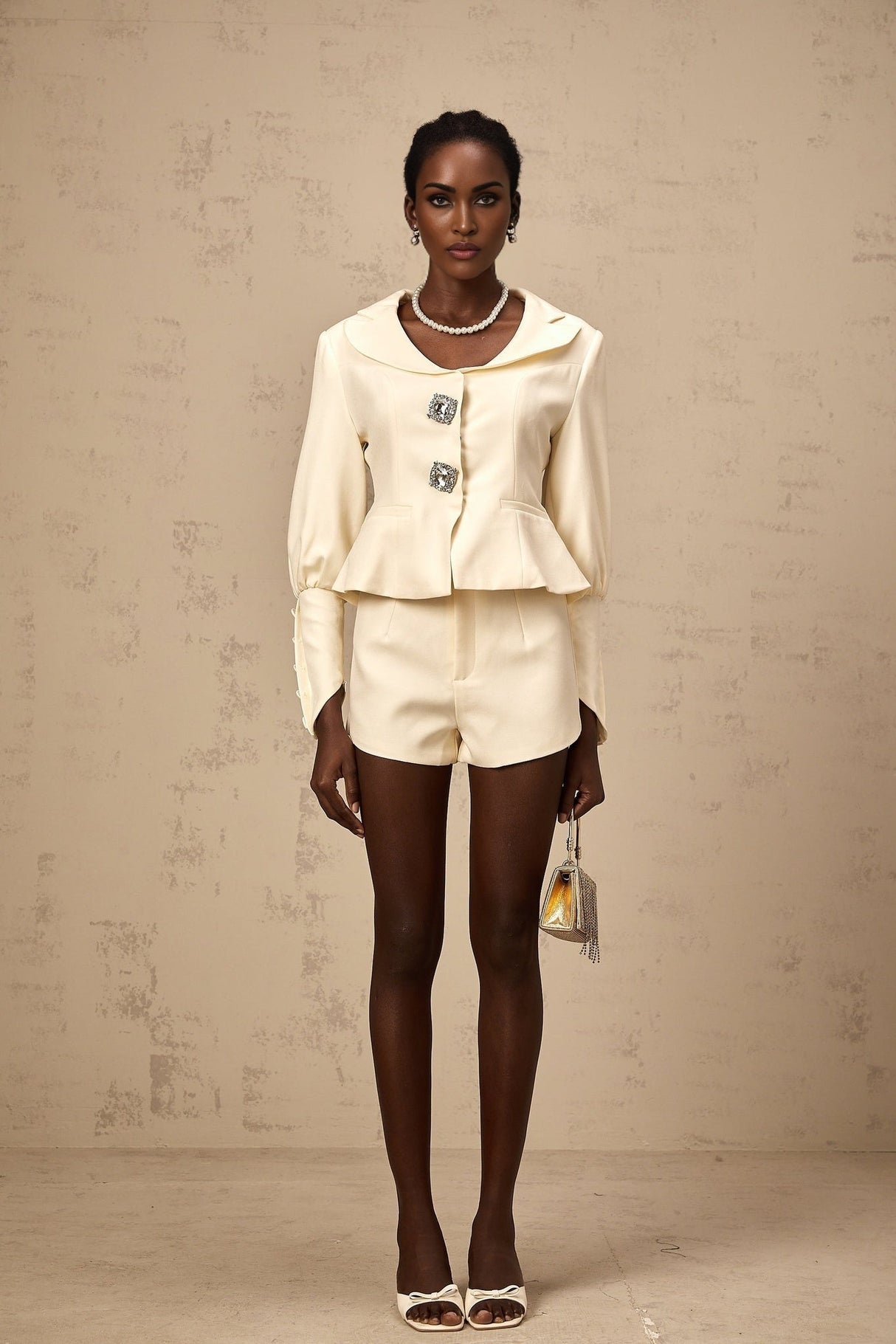 Woman wearing a matching jacket and shorts set embellished with crystal details in a stylish silhouette