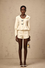 Woman wearing a matching jacket and shorts set embellished with crystal details in a stylish silhouette