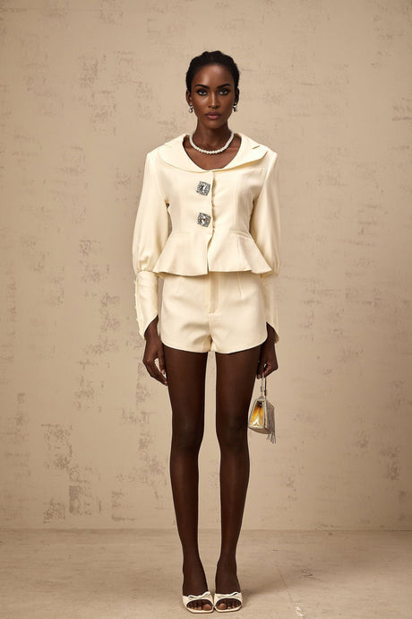 Woman wearing a matching jacket and shorts set embellished with crystal details in a stylish silhouette