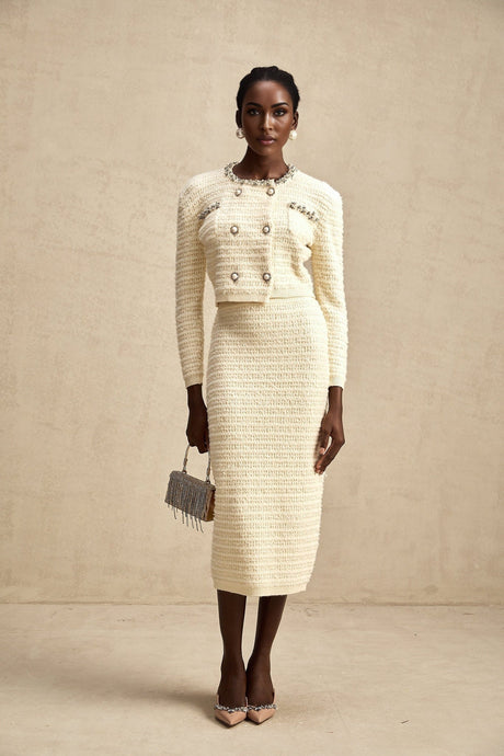 Woman wearing a matching knit cardigan and skirt set named Justine with embellishments on both pieces
