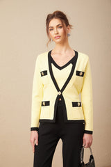 Woman wearing a matching knit set with cardigan vest and trousers featuring contrasting trim details in a light color