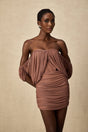 Woman wearing a matching offshoulder bodysuit and skirt set in a solid color fabric