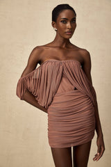 Woman wearing a matching offshoulder bodysuit and skirt set in light fabric