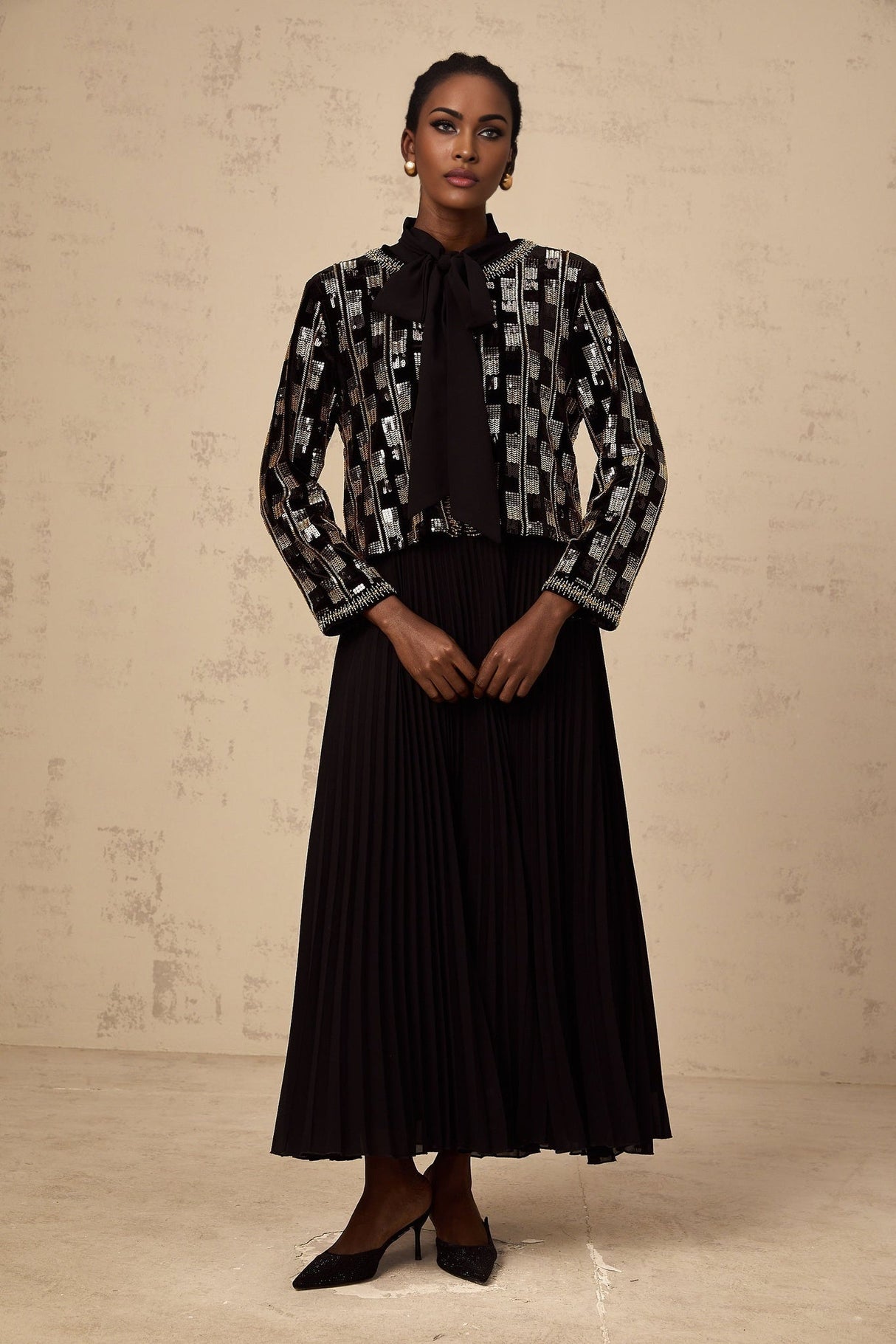 Woman wearing a matching sequined cardigan and dress set in a checkered pattern