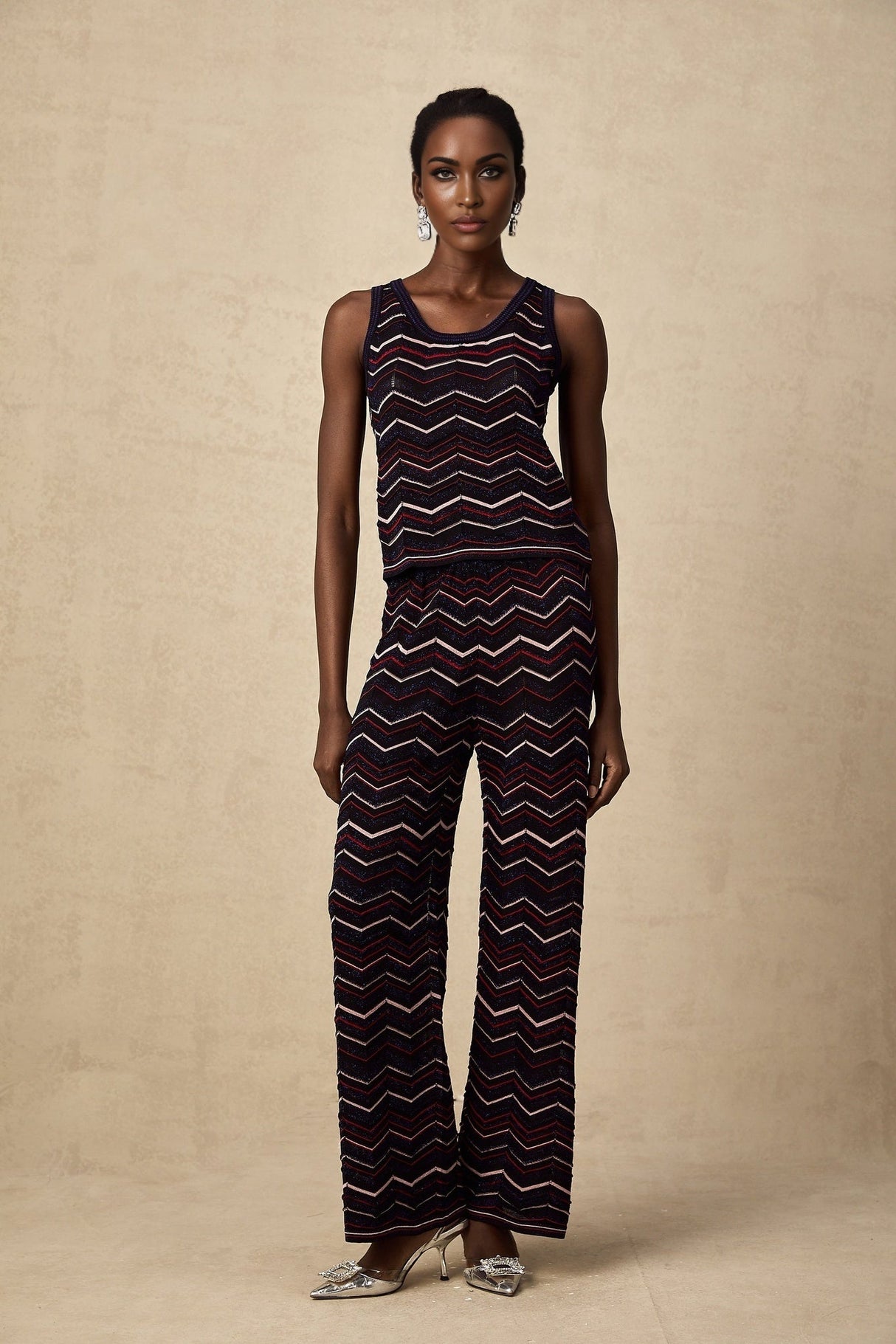 Woman wearing a matching set consisting of a sleeveless crochet knit top and trousers with zigzag pattern in Emmanuelle style