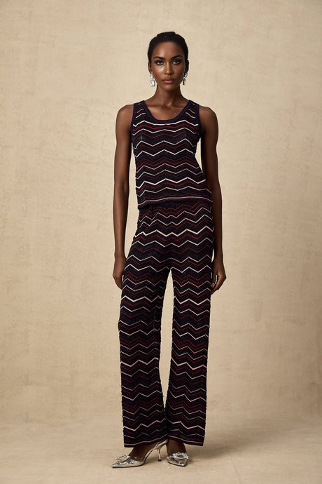 Woman wearing a matching set consisting of a sleeveless crochet knit top and trousers with zigzag pattern in Emmanuelle style