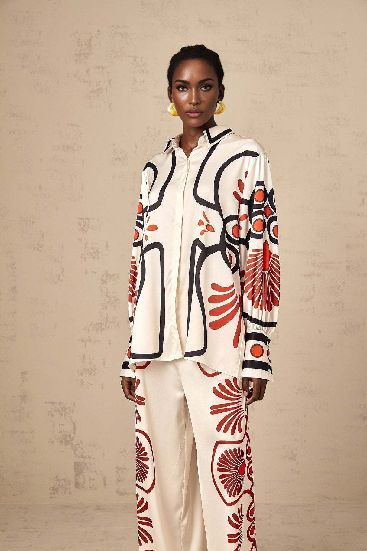 Woman wearing a matching set of shirt and trousers with colorful graphic print pattern
