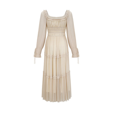 Woman wearing a metallic pleated midi dress with shirred details and a flowy silhouette