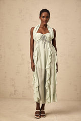 Woman wearing a midi length dress with ruffles and embellishments