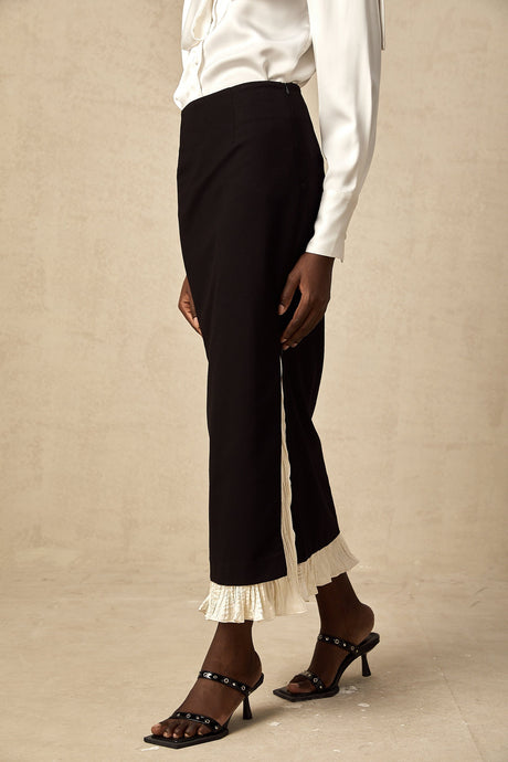 Woman wearing a midi length skirt with color block design and panels in contrasting colors