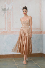 Woman wearing a neutral colored crochet lace cardigan over a matching dress standing in a relaxed pose