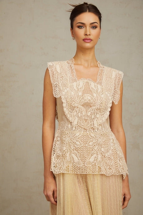 Woman wearing a neutral colored midi dress with floral lace panels and tulle details