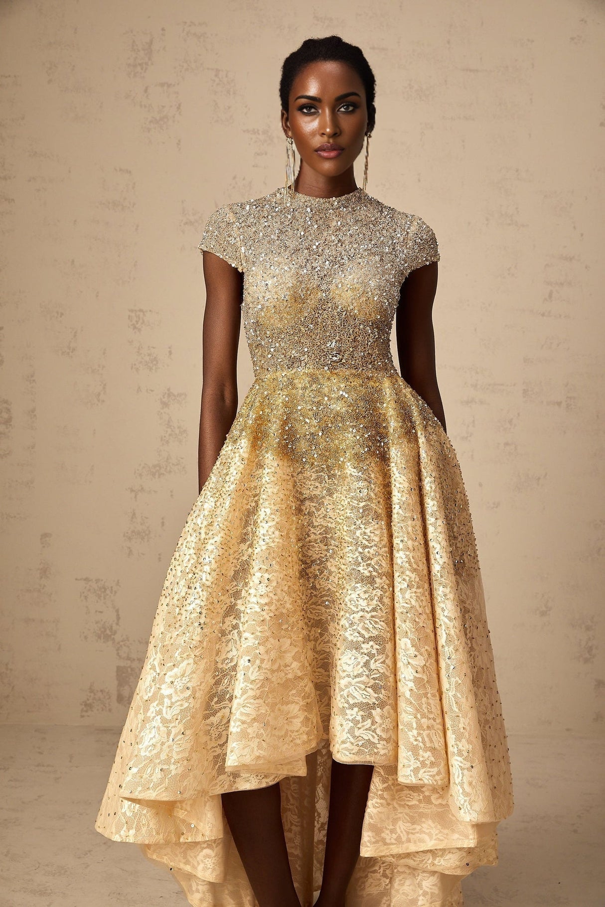 Woman wearing a neutral colored sequin dress with high low hemline